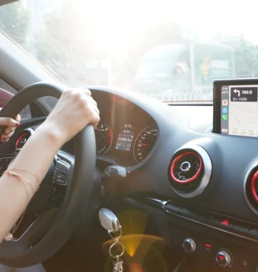 Mãos de motorista no volante de um carro em movimento
